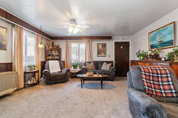 Living room with carpet, ceiling fan, and large windows for natural light. - 6994 Cheam Avenue, Agassiz, Agassiz
