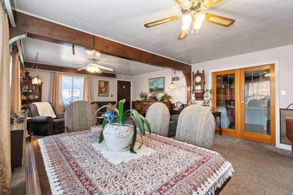 Dining area featuring a patterned tablecloth, plants, and glass doors leading to another room. - 6994 Cheam Avenue, Agassiz, Agassiz