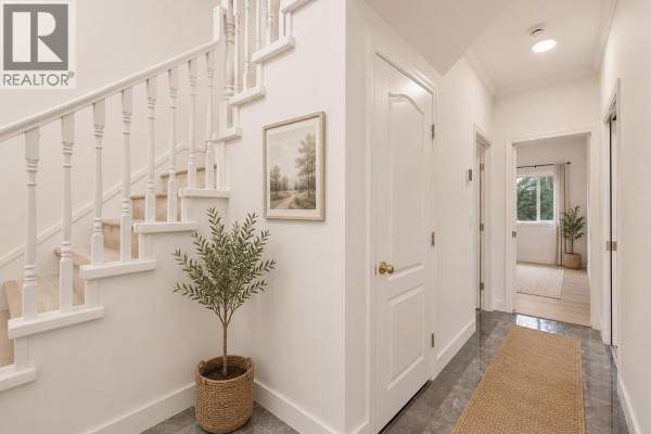 Bright living room featuring a stone fireplace, large windows, and modern decor. - 6998 Fielding Court, Burnaby
