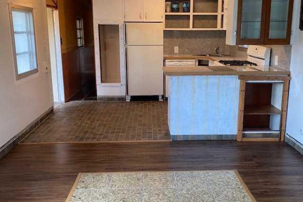 Interior view of a kitchen area with a refrigerator, stove, and light brown tiled floor. - 7, 726 Carmichael Lane, Hinton