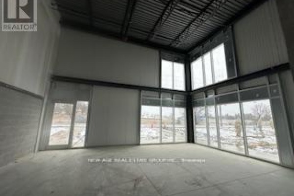 Large open warehouse space with concrete floors, exposed metal ceiling structure, and multiple large windows. - 7 (main Floor-warehouse) - 595 Hanlon Creek Boulevard, Guelph