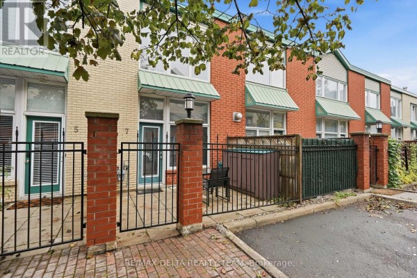 Front exterior of townhouses, showing units numbered 5 and 7 with gated patios. - 7 - 170 Cathcart Street, Ottawa