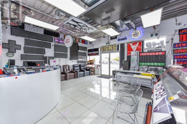 Interior of a commercial space with a reception desk, seating, and signage equipment. - 7 - 1780 Albion Road, Toronto
