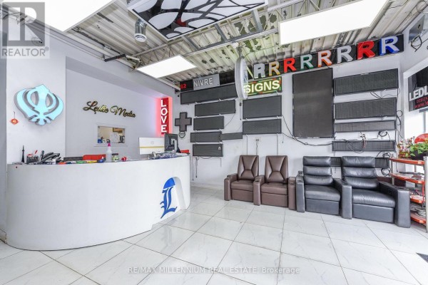 Reception area with a curved desk, chairs, and various LED signs on the walls. - 7 - 1780 Albion Road, Toronto
