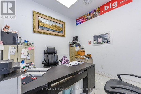 Office space with a desk, chair, computer, printer, and framed artwork on the wall. - 7 - 1780 Albion Road, Toronto