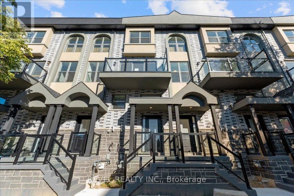 Close-up of the front exterior entrance of a townhouse with gray brick. - 7 - 200 Railway Engine House Way, Whitby