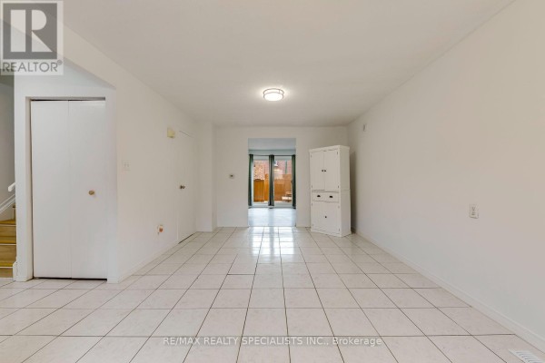 Living or dining area with white walls, white tiled floors, a white cabinet, and a door leading outside. - 7 - 325 Mary Street, Hamilton