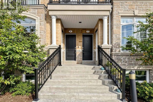 Front entrance of a townhouse with two black doors, number 6 and 7, reached by concrete stairs and black railings. - 7 - 37 Drewry Avenue, Toronto
