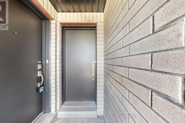 Close-up view of two adjacent townhouse front doors, one dark grey and one black. - 7 - 45 Romilly Avenue, Brampton