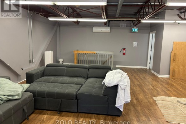 Another angle of the showroom with a desk, display samples, and blue chairs. - 7 - 5509 Canotek Road, Ottawa