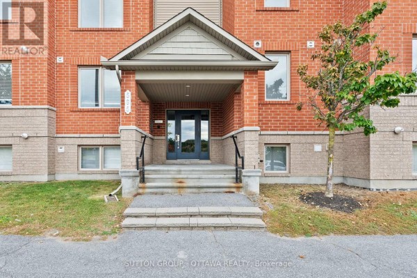 Close-up of the entrance to building 565 Stonefield Private with stairs and a glass door. - 7 - 565 Stonefield Private, Ottawa