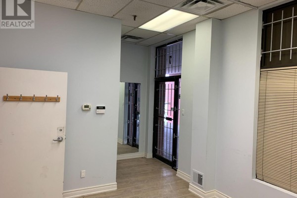 Office interior with blue walls, coat hooks, and a glass door with bars. - #7 - 60 Amber Street, Markham