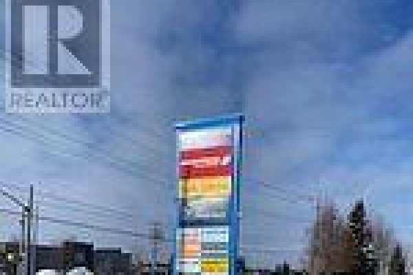 Tall, blue, multi-tenant sign with colorful business names against a cloudy sky. - 7 - 649 Yonge Street, Barrie