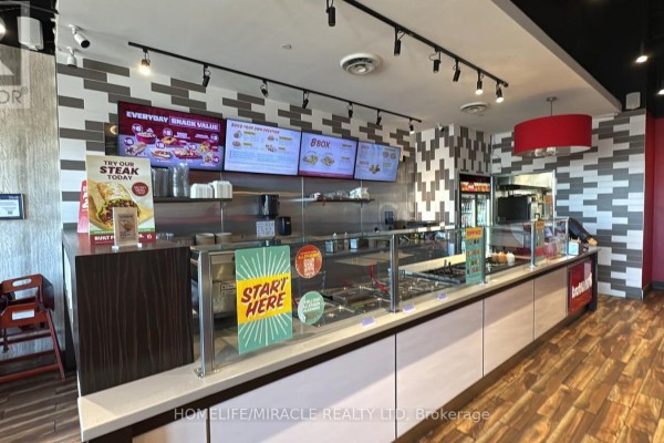 Seating area in barBurrito with tables and colorful decor - 7 - 900 Watters Road, Ottawa
