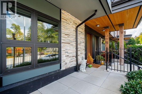Close-up of townhouse entrance with stacked stone, wood soffit, and glass windows. - 7 50 Seaview Drive, Port Moody