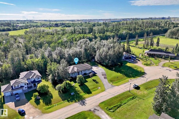 Aerial view of houses on a cul-de-sac surrounded by trees and green lawns. - #7 53216 Rge Road 264, Rural Parkland County