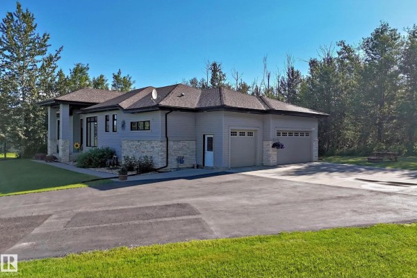 Right side of a modern grey home featuring a three-car garage and paved driveway. - #7 53216 Rge Road 264, Rural Parkland County
