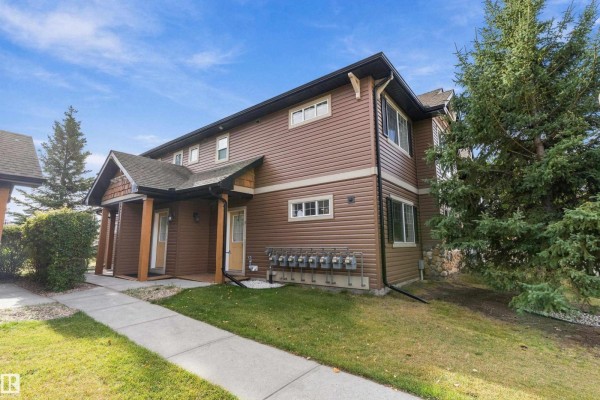 Exterior of a brown townhouse with white trim and a covered entrance with wooden posts. - #7 671 Silver Berry Rd Nw, Edmonton