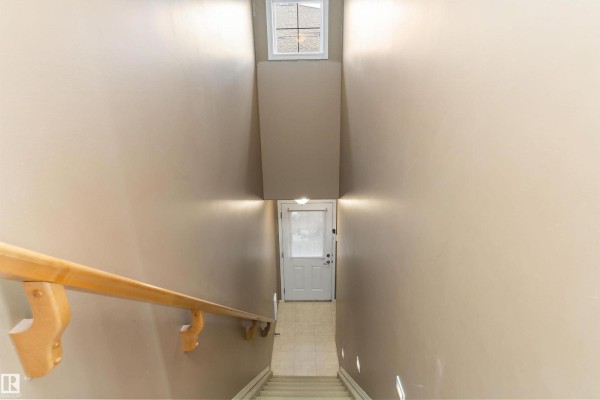 Stackable white washer and dryer in a closet next to a staircase. - #7 671 Silver Berry Rd Nw, Edmonton