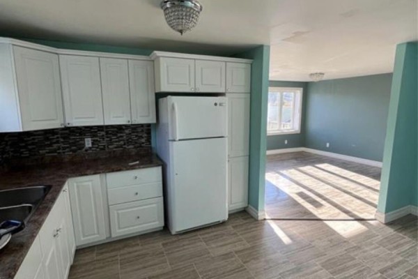 Kitchen with white cabinets, a double sink under a window, and a white refrigerator. - 7-9 Holmes Road, Shearstown