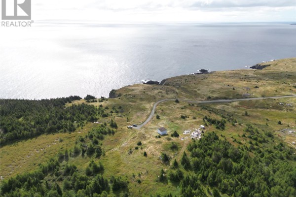 Expansive aerial view showcasing the oceanfront property with a house, trees, and coastal terrain. - 7 Amys Hole Road, Jobs Cove