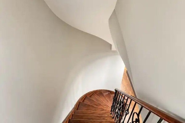 A curved wooden staircase with black ornate metal railings leading upwards. - 7 Aquilina Court, Ajax