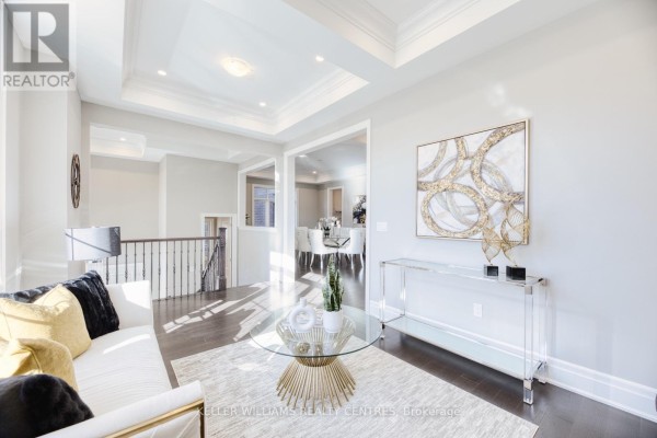 Living room with a coffered ceiling, sofa, glass coffee table, and view of dining room. - 7 Becky Cheung Court, Toronto