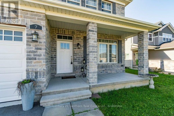 Close-up of the house entrance with stone pillars, steps, a white door, and lanterns. - 7 Cottonwood Drive, Belleville