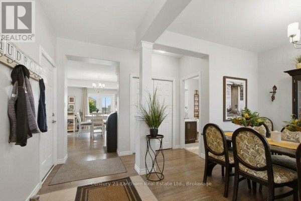 Dining room with a large table, upholstered chairs, a china cabinet, and white curtains. - 7 Cottonwood Drive, Belleville