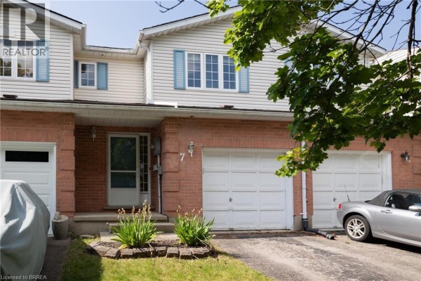 Close-up of townhouse entrance at 7 Graystone Court with brick facade and garage doors. - 7 Graystone Court, Paris