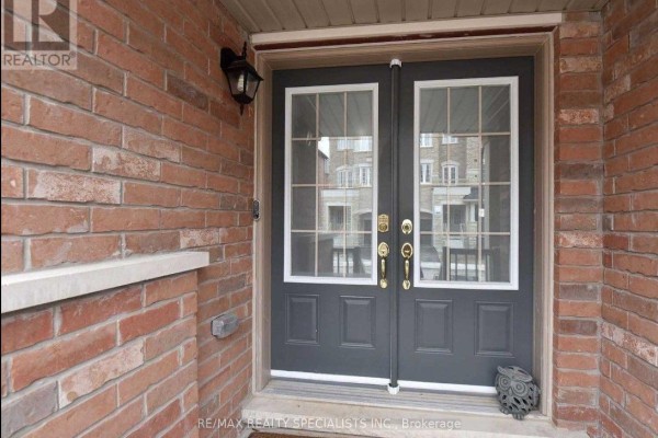 Close-up of the dark grey front double doors with glass panes and brick exterior. - 7 Hobart Gardens, Brampton