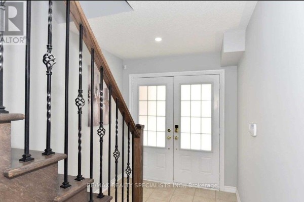 View from inside looking towards the front entrance with double glass doors and staircase. - 7 Hobart Gardens, Brampton