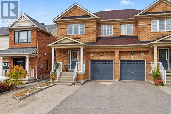 Exterior of a brick townhouse with two garage doors and a covered front entrance. - 7 Isabella Garden Lane, Whitchurch Stouffville