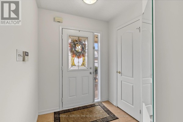 Interior entrance foyer with a white door, stained glass sidelight, and a beige rug. - 7 Isabella Garden Lane, Whitchurch Stouffville