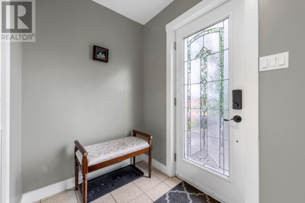 Interior entryway with grey walls, tiled floor, and a glass front door. - 7 Jacobs Place, Mount Pearl
