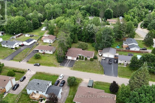 Aerial perspective of the Laurentian Hills neighborhood, showing multiple houses and surrounding forest. - 7 Martin Street, Laurentian Hills