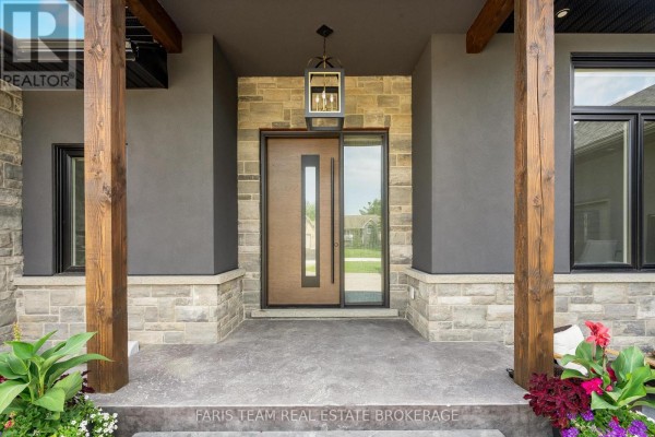 Close-up of the modern front door with wood accents, stone, and pendant light fixture. - 7 Reynolds Road, Tiny