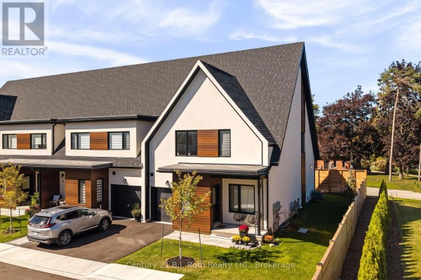Aerial view of a townhouse complex showing the property at 7 Rice Lane Road with a driveway, garage, and yard. - 7 Rice Lane Road, Orillia