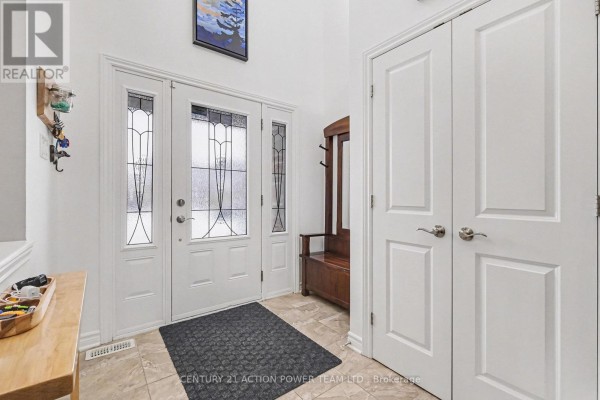 Interior foyer with tiled floor, white doors, wood bench, and leaded glass front door. - 7 Richer Street S, North Stormont