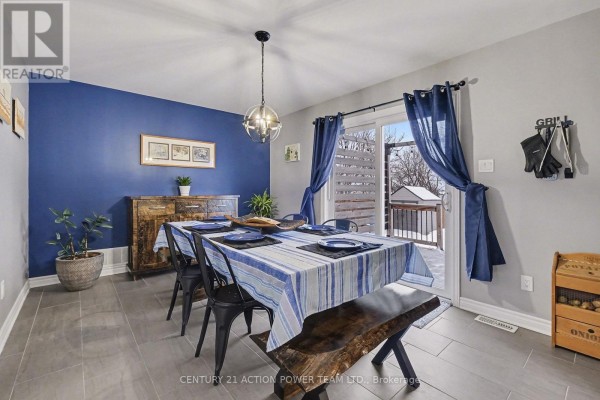 Dining room with blue accent wall, set table, pendant light, and sliding glass door to deck. - 7 Richer Street S, North Stormont