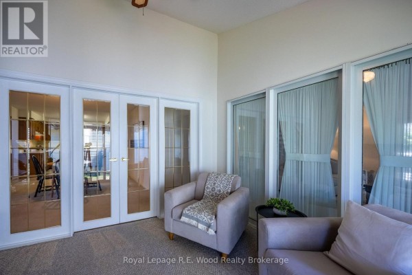 Living room with french doors, armchair, sofa, and large windows - 7 Seres Drive Tillsonburg