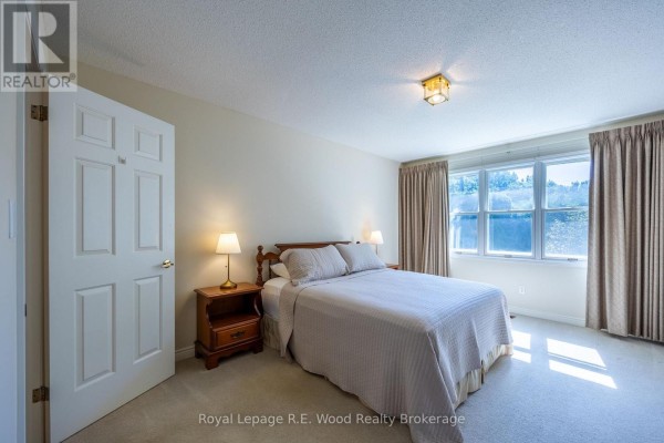 Bedroom with double bed, nightstands, and large windows - 7 Seres Drive Tillsonburg