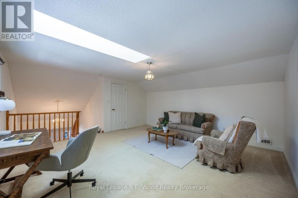Attic living room with sofa, armchair, desk, and skylight - 7 Seres Drive Tillsonburg