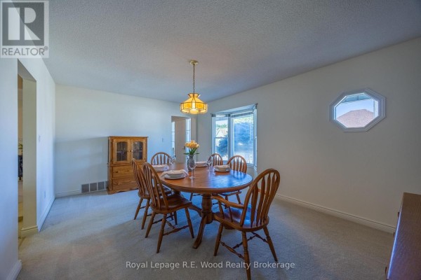 Dining room with round table, chairs, hutch, and bay window - 7 Seres Drive Tillsonburg