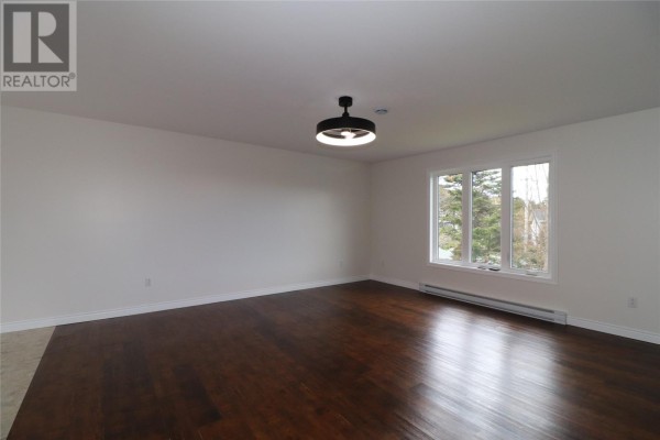 Kitchen with wood cabinets, white appliances, an island, and a sliding glass door to a deck. - 7 Squires Road, Paradise