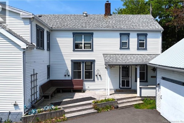 Close-up of the covered porch with wooden steps, benches, and a screen door. - 7 St. Croix Street, St  Stephen