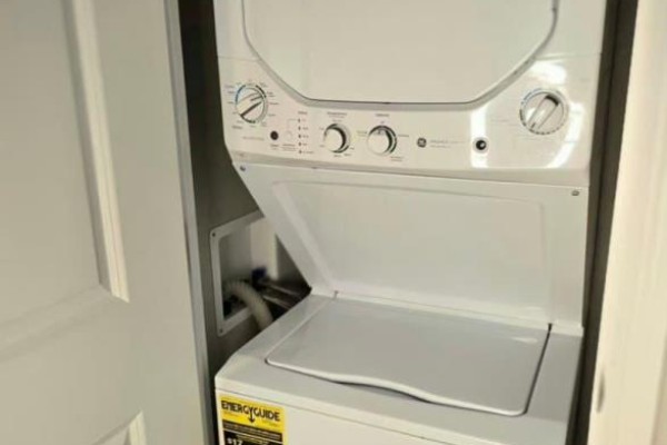 Stackable white GE washer and dryer unit inside a closet with beige walls. - 7 Willow - 4449 Milburough Line, Burlington