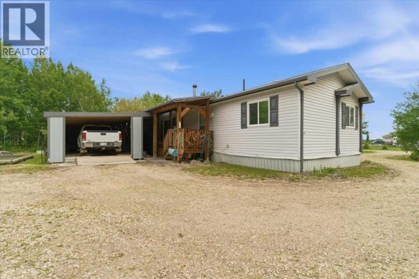 Storage room with white walls, grey carpet, and boxes and a vacuum cleaner. - 70, 25039 Township Road 722, Rural Grande Prairie No  1, County Of