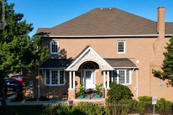 Exterior of a brick townhouse with a white arched entryway and bay windows. - 70 - 190 Harding Boulevard W, Richmond Hill