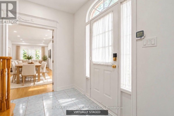 Interior foyer with light blue tile floor, white door, and view into dining room. - 70 - 190 Harding Boulevard W, Richmond Hill